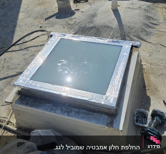 עבודת התקנה של חלון גג עם כלים על הגג